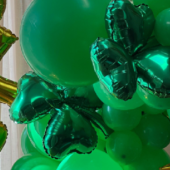 Zielono-złota dekoracja z balonów foliowych i lateksowych na urodziny lub event - balony w kształcie serc, liter i gwiazd