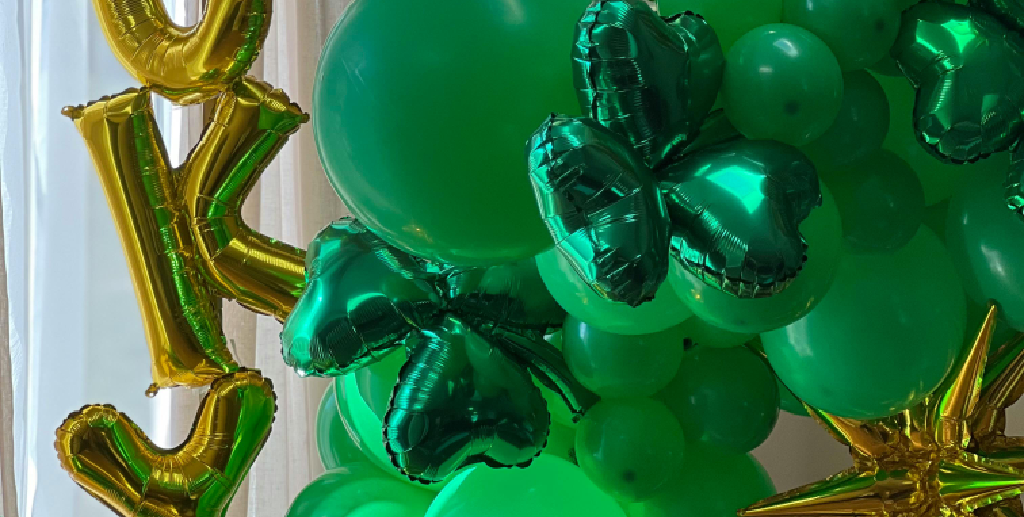 Zielono-złota dekoracja z balonów foliowych i lateksowych na urodziny lub event - balony w kształcie serc, liter i gwiazd